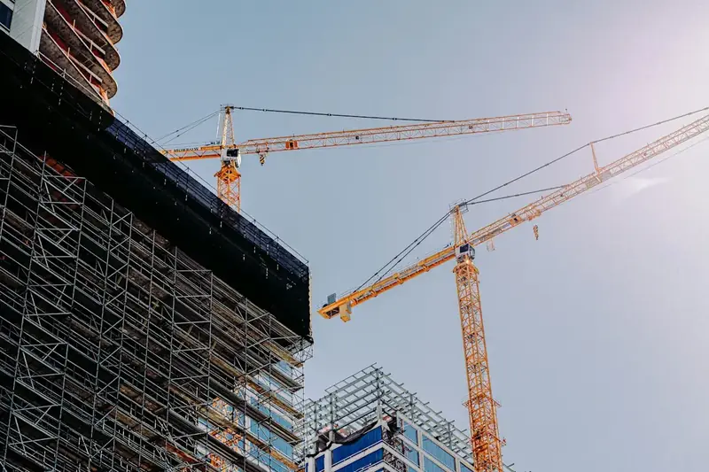 Grues à tour au-dessus d'un immeuble en construction